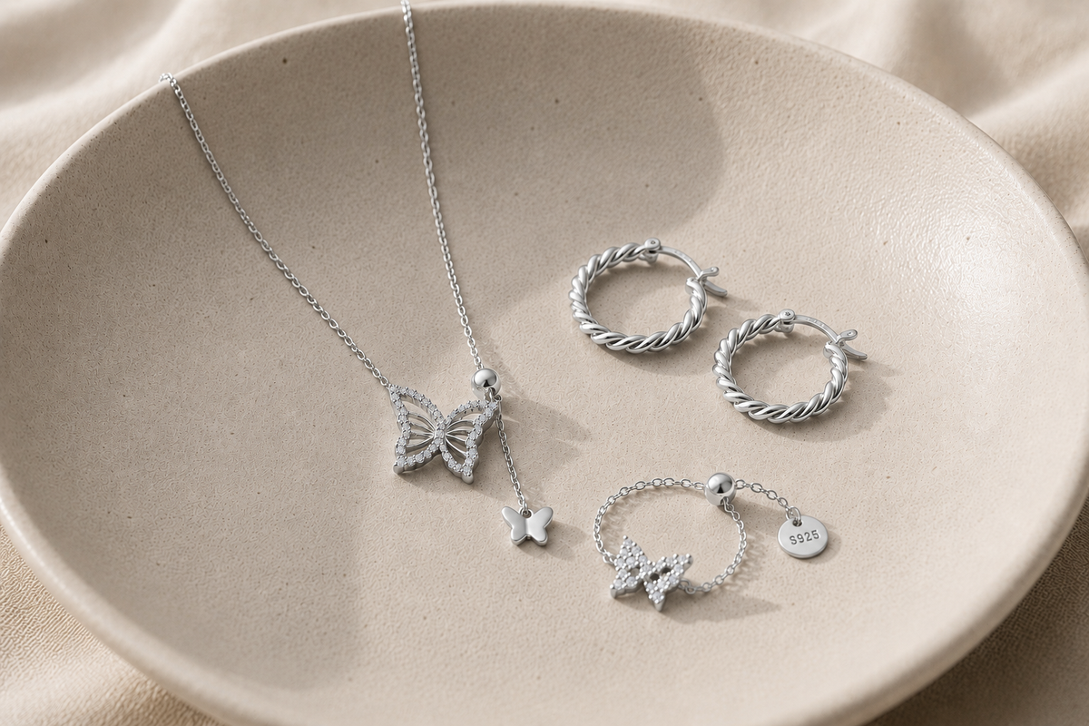 Silver-coloured earrings and necklace arranged on a white plate