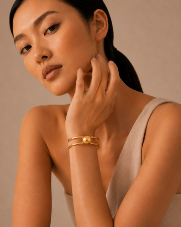 Gold bracelet with sculptural links worn on the wrist