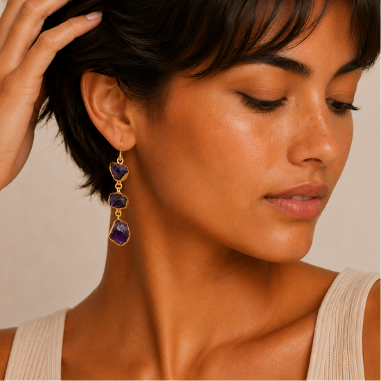 Amethyst Fall Earrings worn on the ear, with three irregular purple stones on each drop