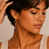 Amethyst Fall Earrings worn on the ear, with three irregular purple stones on each drop