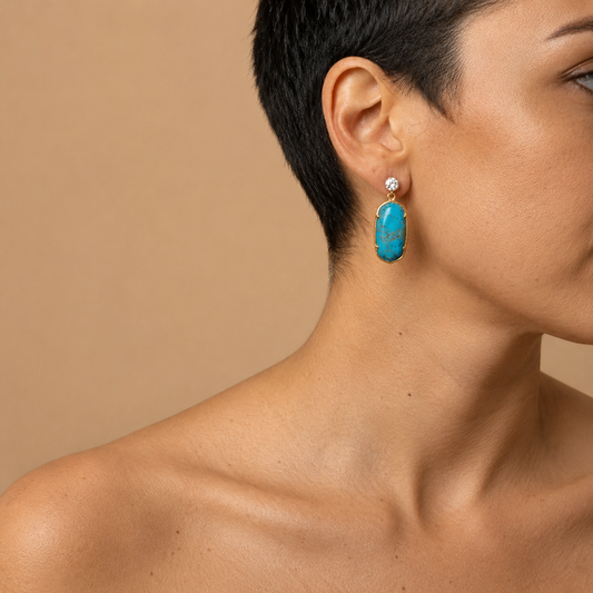 Azure Hold Earrings worn on the ear, with turquoise-coloured rectangular stone drops