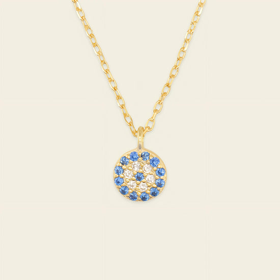 Blue Halo Necklace with a round pendant with blue and clear stone accents in gold finish