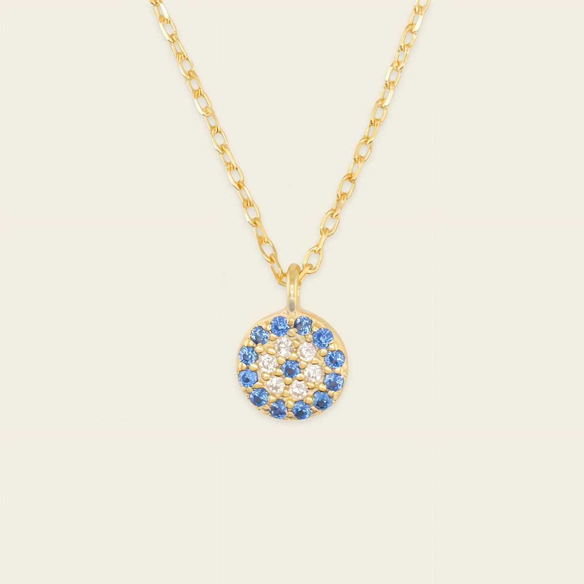 Blue Halo Necklace with a round pendant with blue and clear stone accents in gold finish