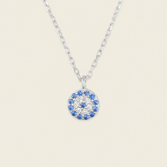 Blue Halo Necklace with a round pendant with blue and clear stone accents in silver finish