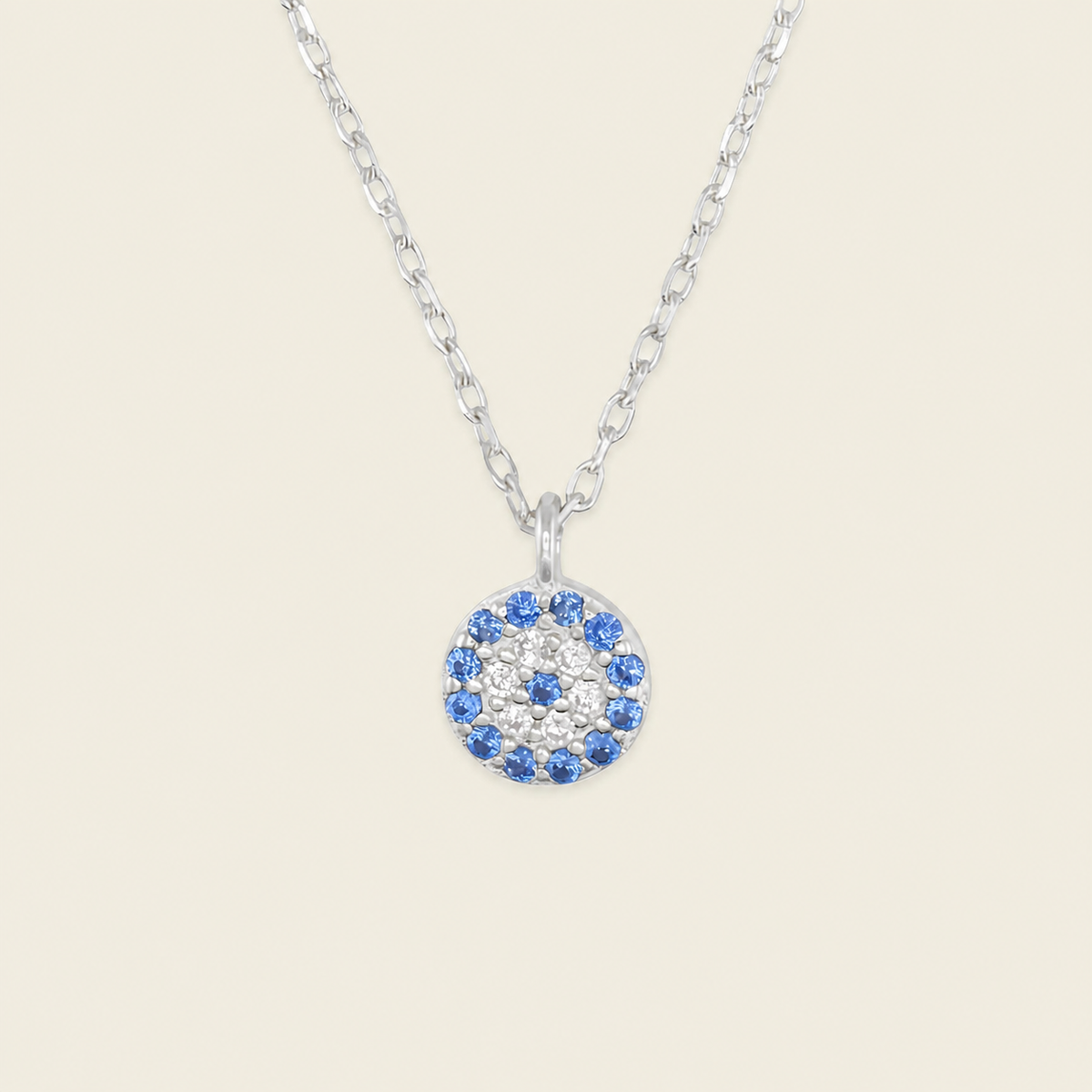Blue Halo Necklace with a round pendant with blue and clear stone accents in silver finish