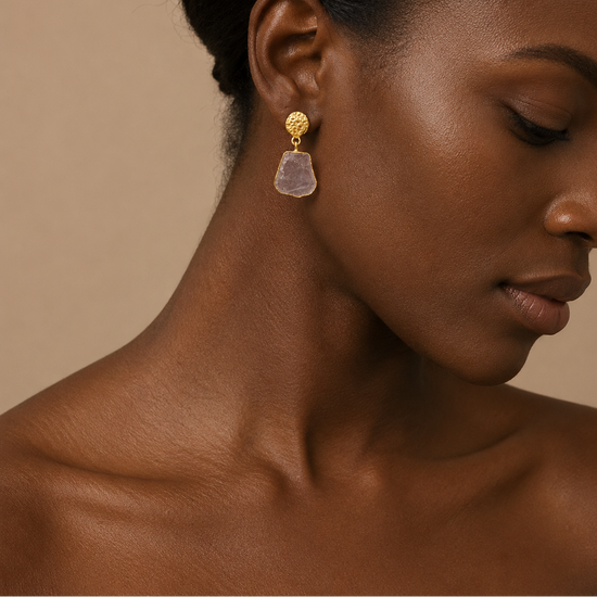 Blush Halo Earrings worn on the ear, with pale irregular stone drops in gold-coloured settings