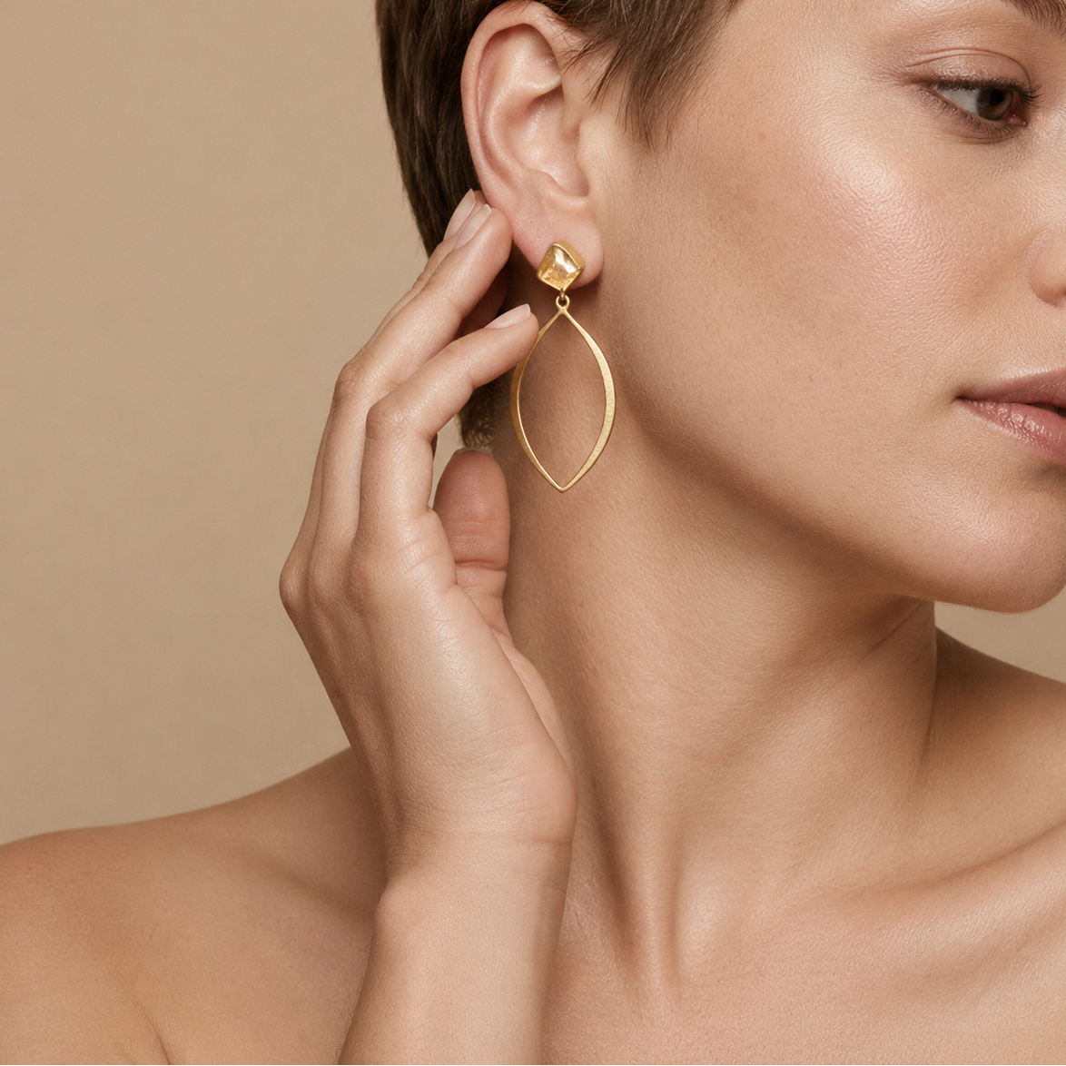 Citrine Orbit Earrings worn on the ear, with pale amber-coloured stones above open oval drops