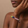Continuum Smooth Bracelet worn on the wrist, with multicoloured round beads and a curved central stone bar