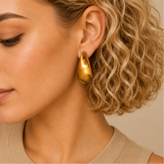 Crescent Sweep Earrings worn on the ear in gold finish