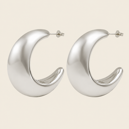 Crescent Sweep Earrings with broad polished crescent-shaped hoops in silver finish