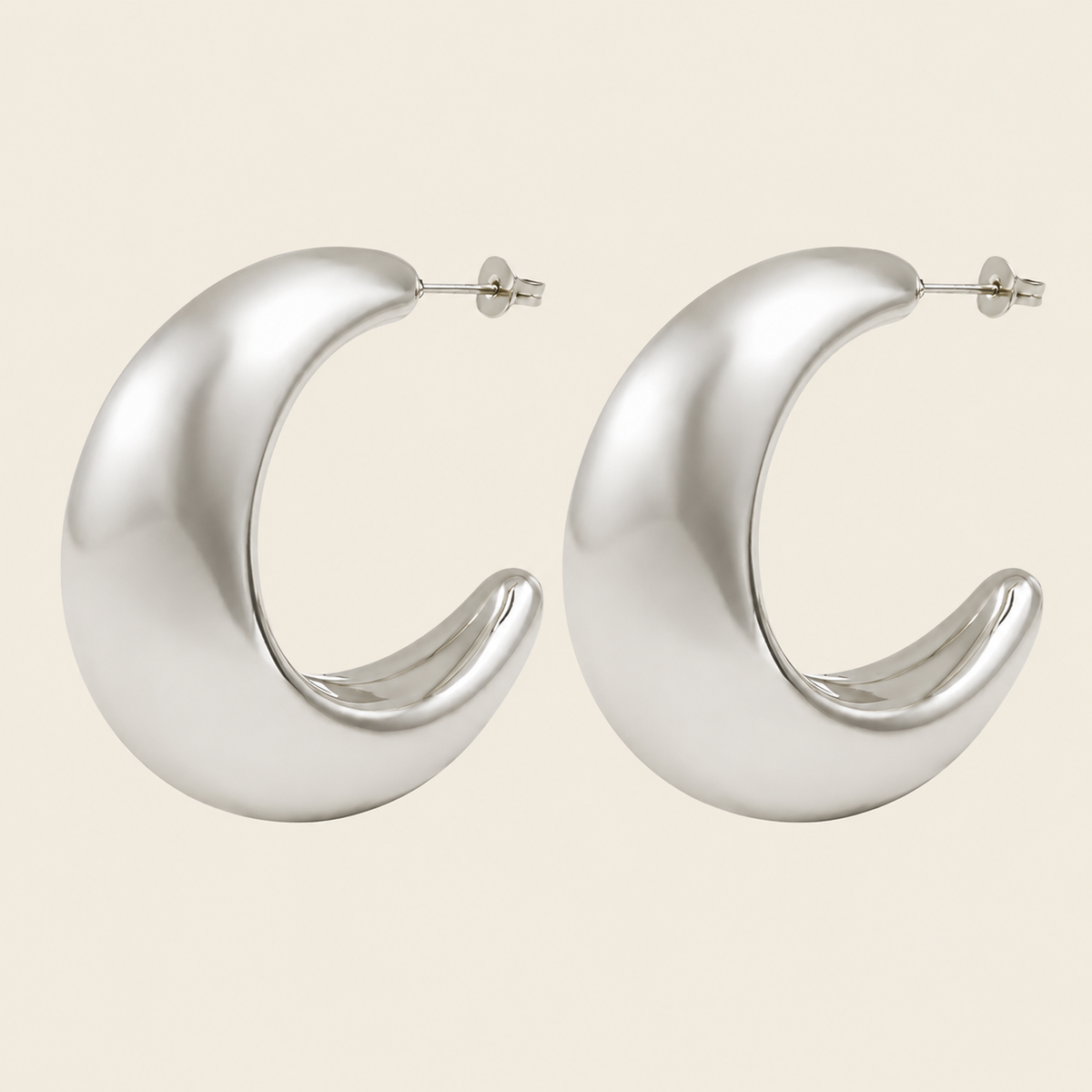 Crescent Sweep Earrings with broad polished crescent-shaped hoops in silver finish