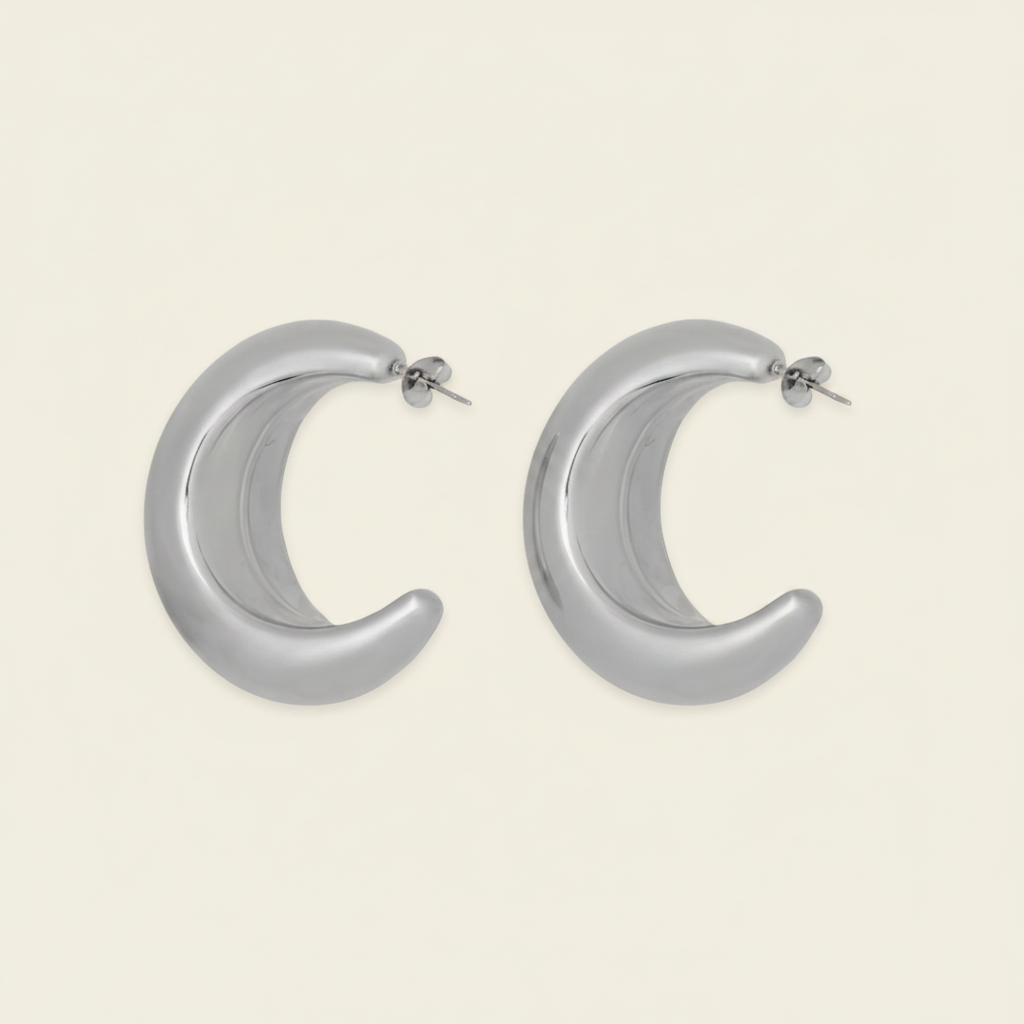 Crescent Sweep Earrings with broad polished crescent-shaped hoops in silver finish