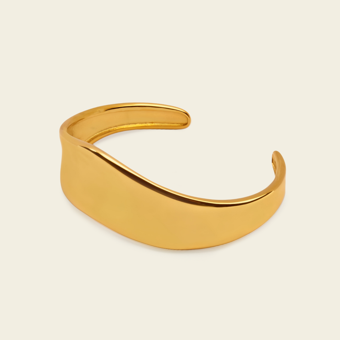 Crest Band Cuff with a broad polished band with a wavy edge in gold finish