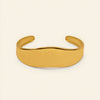 Crest Band Cuff with a broad polished band with a wavy edge in gold finish