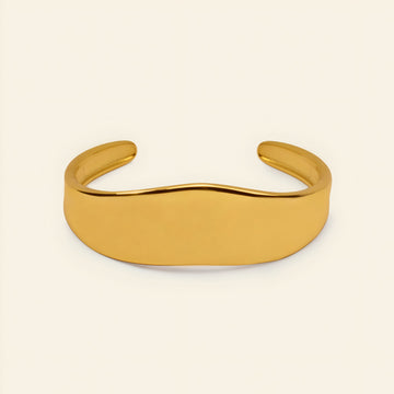 Crest Band Cuff with a broad polished band with a wavy edge in gold finish