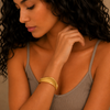 Crest Band Cuff worn on the wrist in gold finish