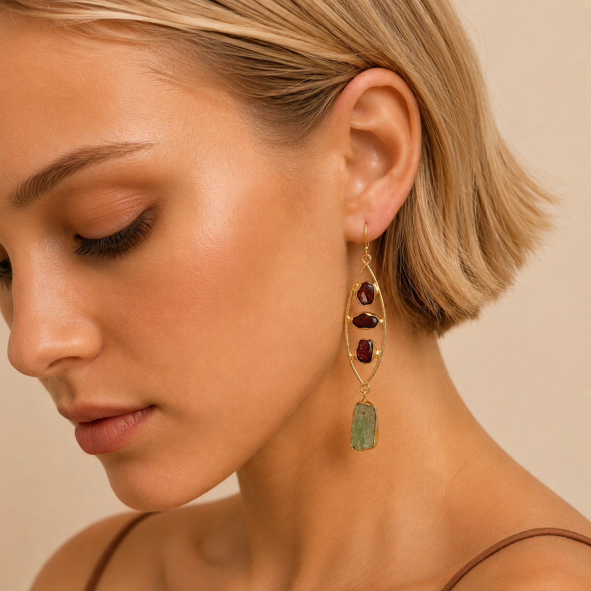 Crimson Grove Earrings worn on the ear, with dark purple stones and elongated open frames