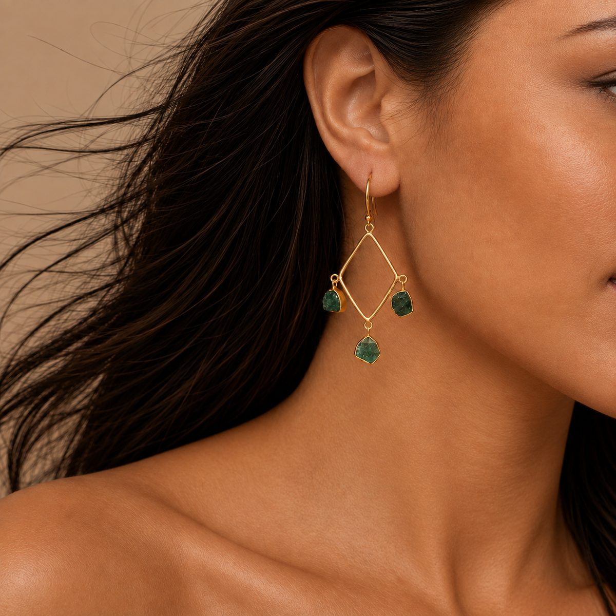 Emerald Frame Earrings worn on the ear, with open geometric frames and green stone accents