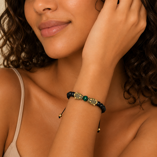 Emerald Leopard Bracelet worn on the wrist, with dark beads, a green centre bead and gold-coloured leopard accents