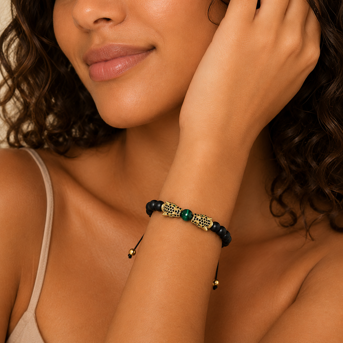 Emerald Leopard Bracelet worn on the wrist, with dark beads, a green centre bead and gold-coloured leopard accents