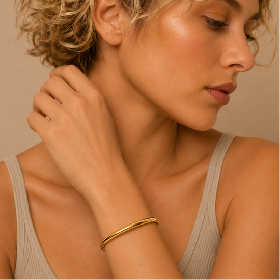 Fine Curve Cuff worn on the wrist in gold finish