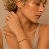 Fine Curve Cuff worn on the wrist in gold finish