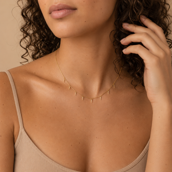 Fine Trace Necklace worn at the neckline in gold finish