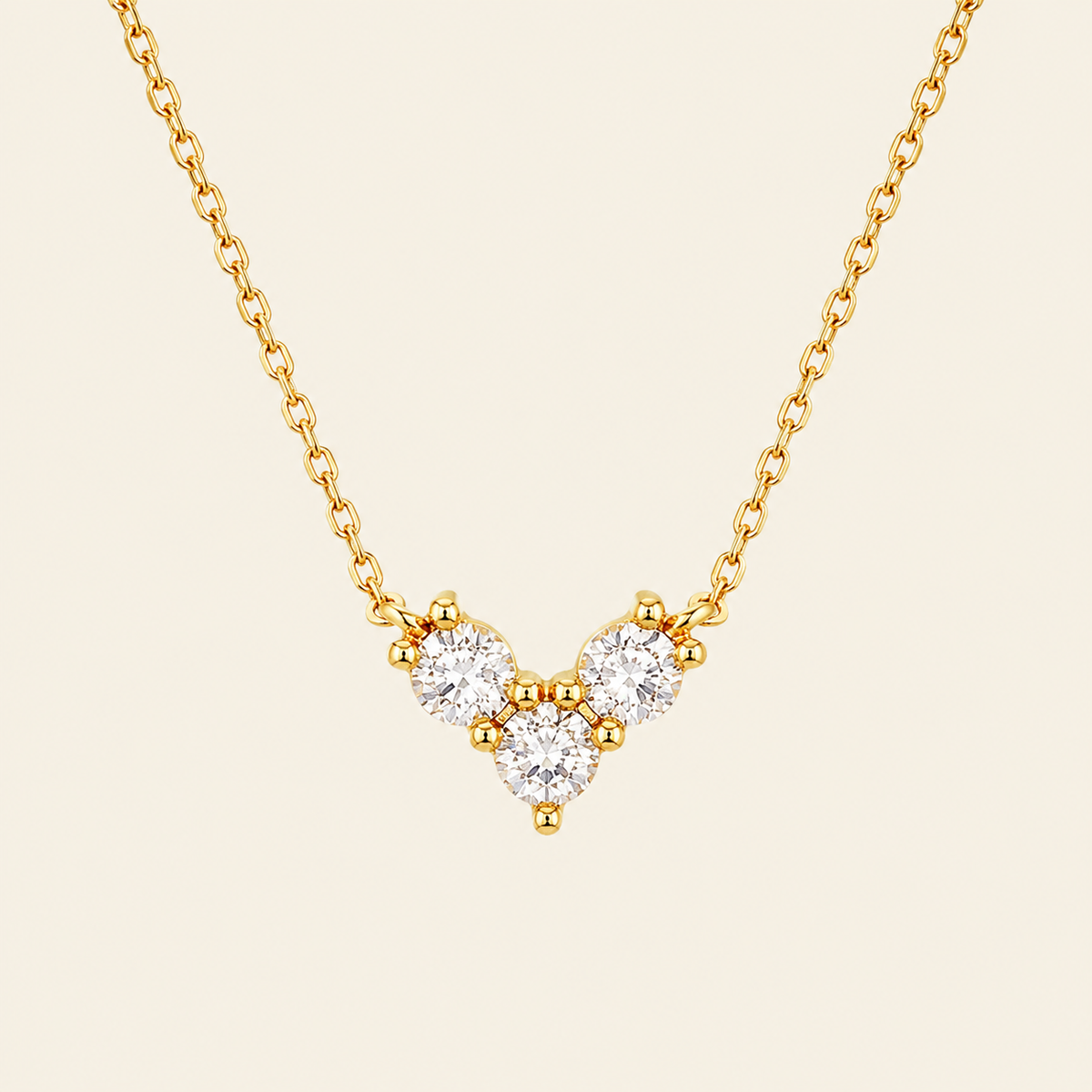 Fine Trio Necklace with a small triangular cluster of clear stones in gold finish