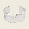 Fluid Edge Cuff with a broad polished open band with notched edges in gold finish