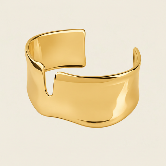 Fluid Edge Cuff with a broad polished open band with notched edges in gold finish