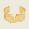 Fluid Edge Cuff with a broad polished open band with notched edges in gold finish