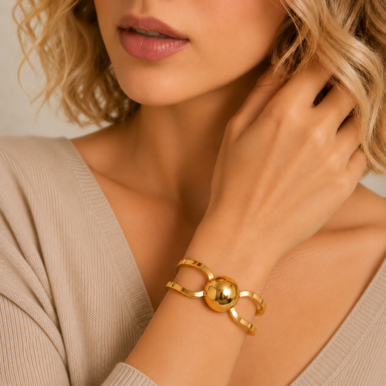 Framed Orb Bangle worn on the wrist in gold finish