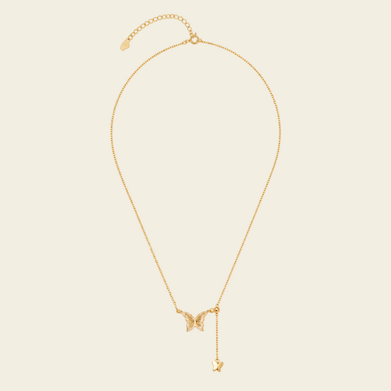 Grace Wing Necklace with a butterfly motif and a hanging clear stone in gold finish