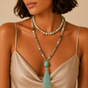 Harbour Mala Necklace worn at the neckline, with pale stone beads and a turquoise-coloured tassel