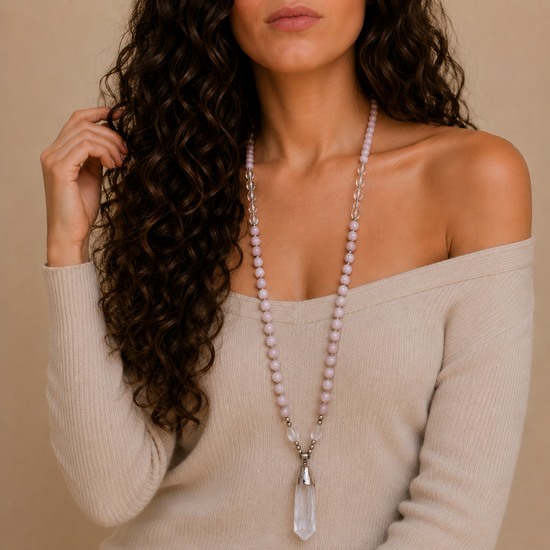 Hushed Point Necklace worn at the neckline, with pale pink beads and a translucent pointed pendant