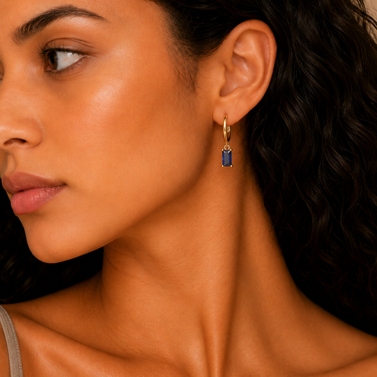Indigo Baguette Earrings worn on the ear in gold finish