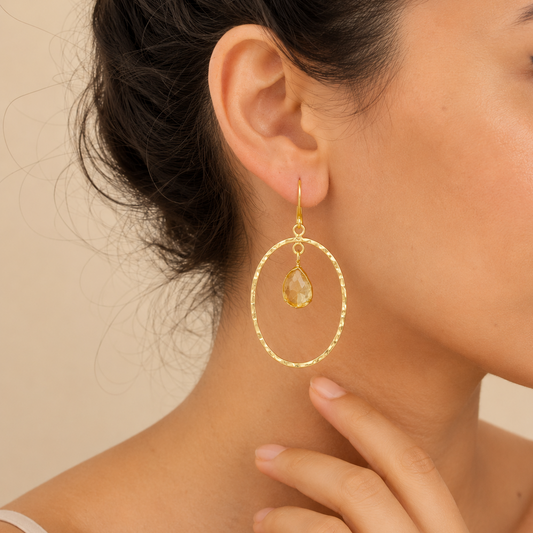 Inner Halo Earrings worn on the ear, with open circular frames and small warm-toned stone drops