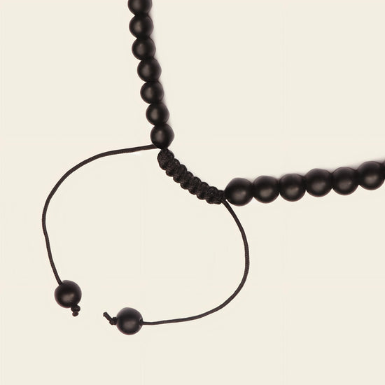 Iron Tide Necklace with dark stone beads and an open triangular pendant