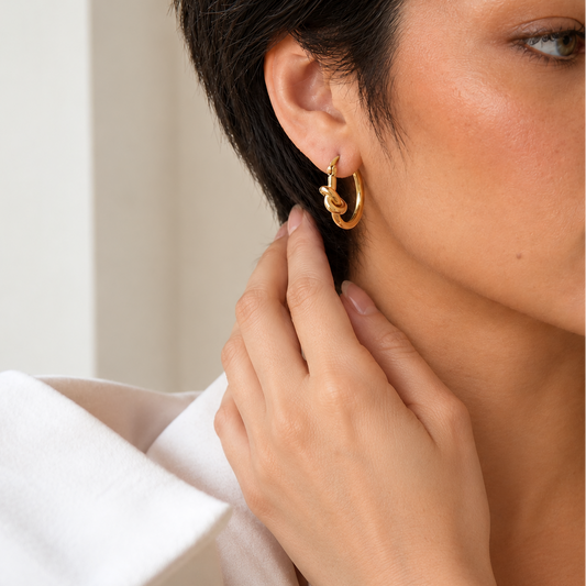 Knotted Loop Earrings worn on the ear in gold finish