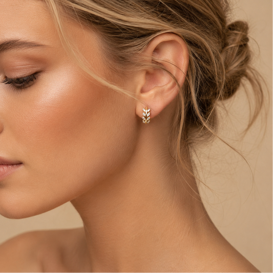 Laurel Arc Earrings worn on the ear in gold finish