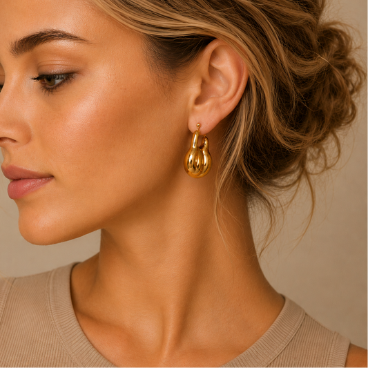Liquid Loop Earrings worn on the ear in gold finish