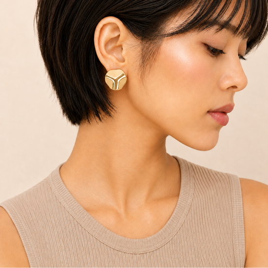 Molten Disc Earrings worn on the ear in gold finish