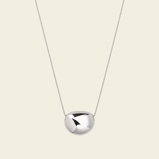 Molten Pebble Necklace with a fine chain and rounded pebble-shaped pendant in silver finish