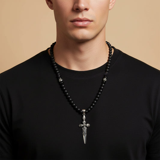 Night Blade Necklace worn at the neckline, with dark beads and a sword-shaped pendant