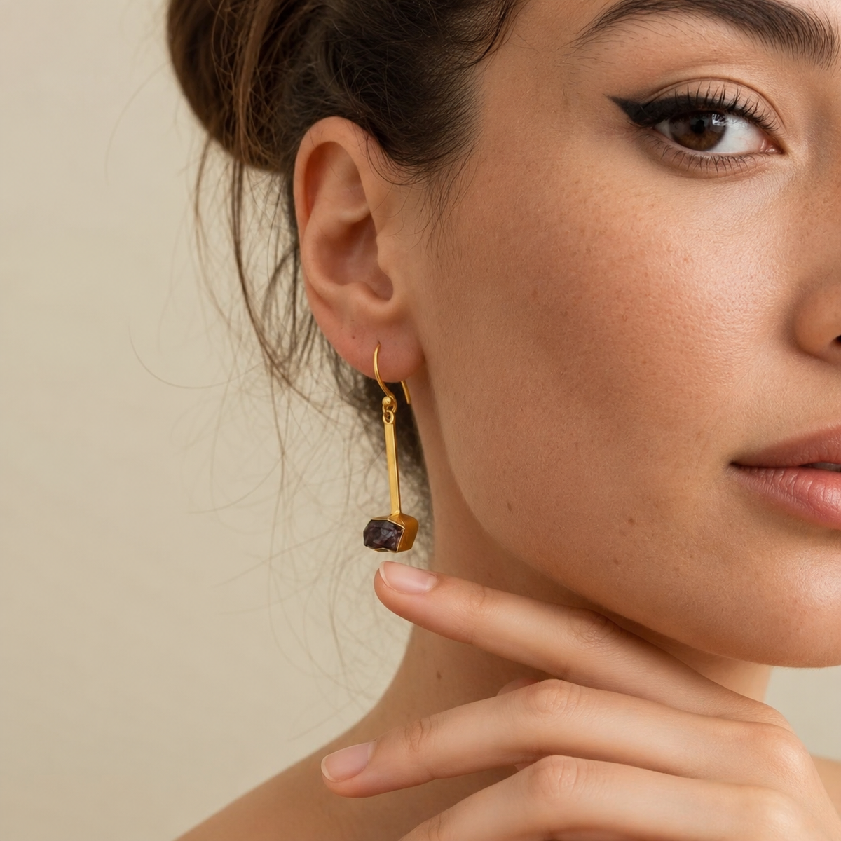 Night Drop Earrings worn on the ear, with long gold-coloured chains and dark stone drops