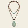 Ocean Drift Necklace with earth-toned beads and a turquoise-coloured teardrop pendant