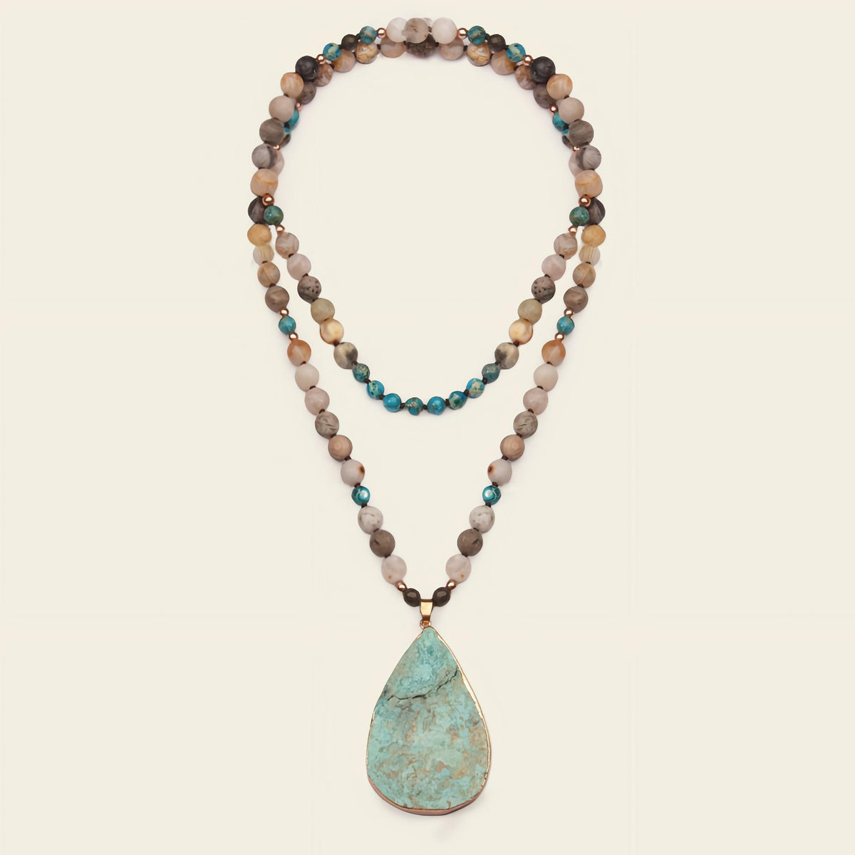 Ocean Drift Necklace with earth-toned beads and a turquoise-coloured teardrop pendant