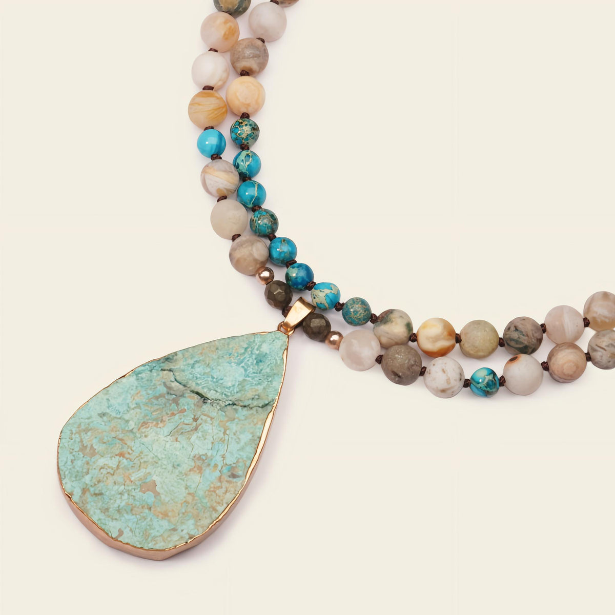 Ocean Drift Necklace with earth-toned beads and a turquoise-coloured teardrop pendant
