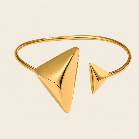 Offset Apex Cuff with an open band with asymmetric triangular ends in gold finish