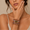 Pattern Hold Bracelet worn on the wrist, with layered red and earth-toned beads